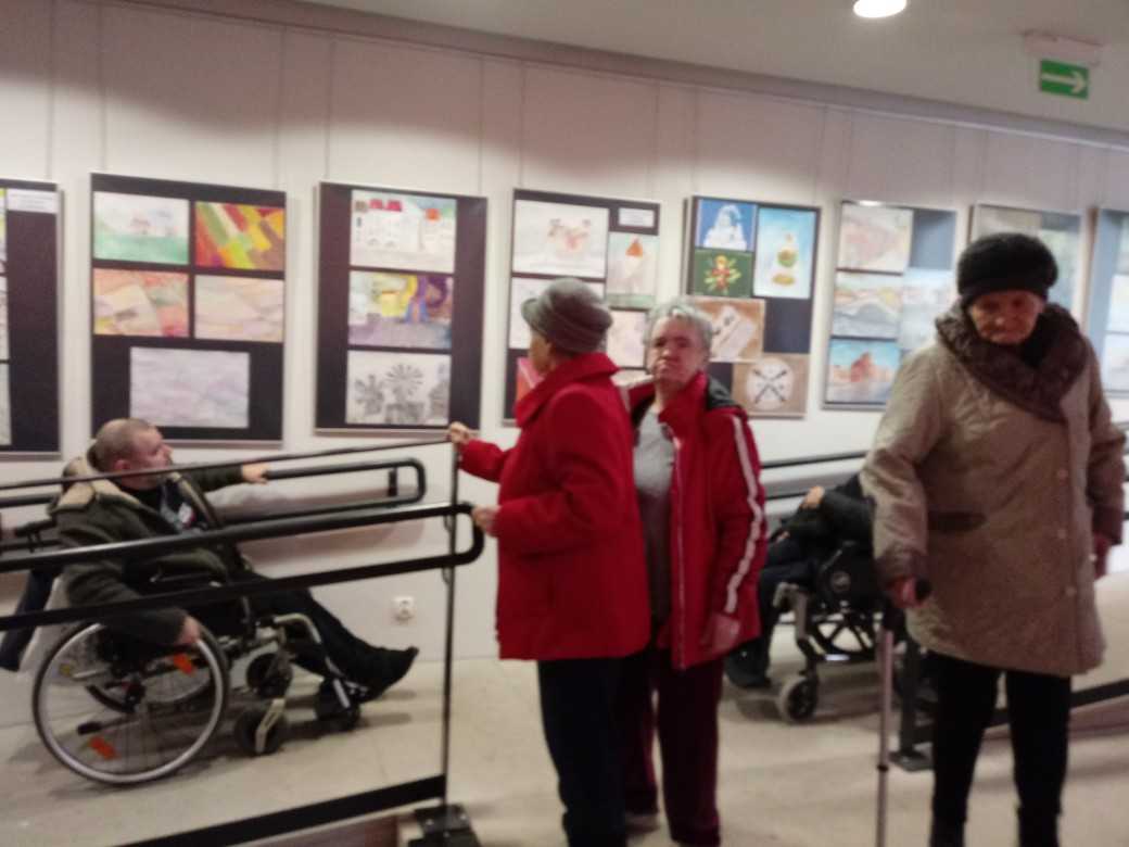 mieszkańcy DPS oglądają wystawę prac plastycznych