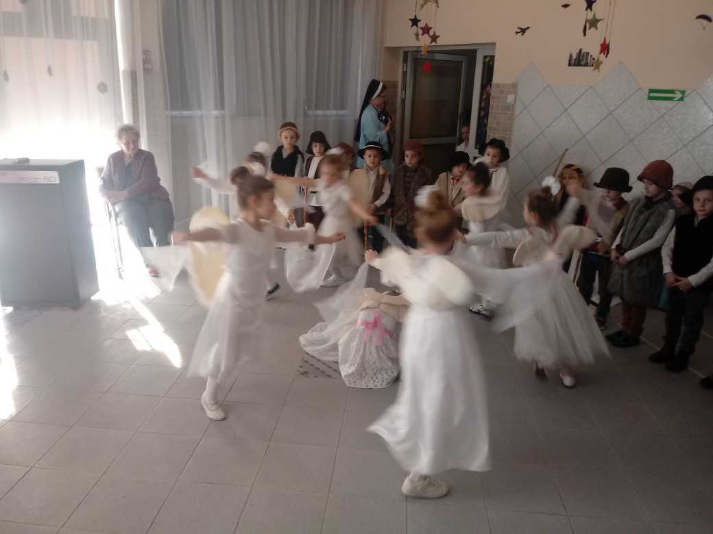 przedszkolaki przebrane za anioły biegają