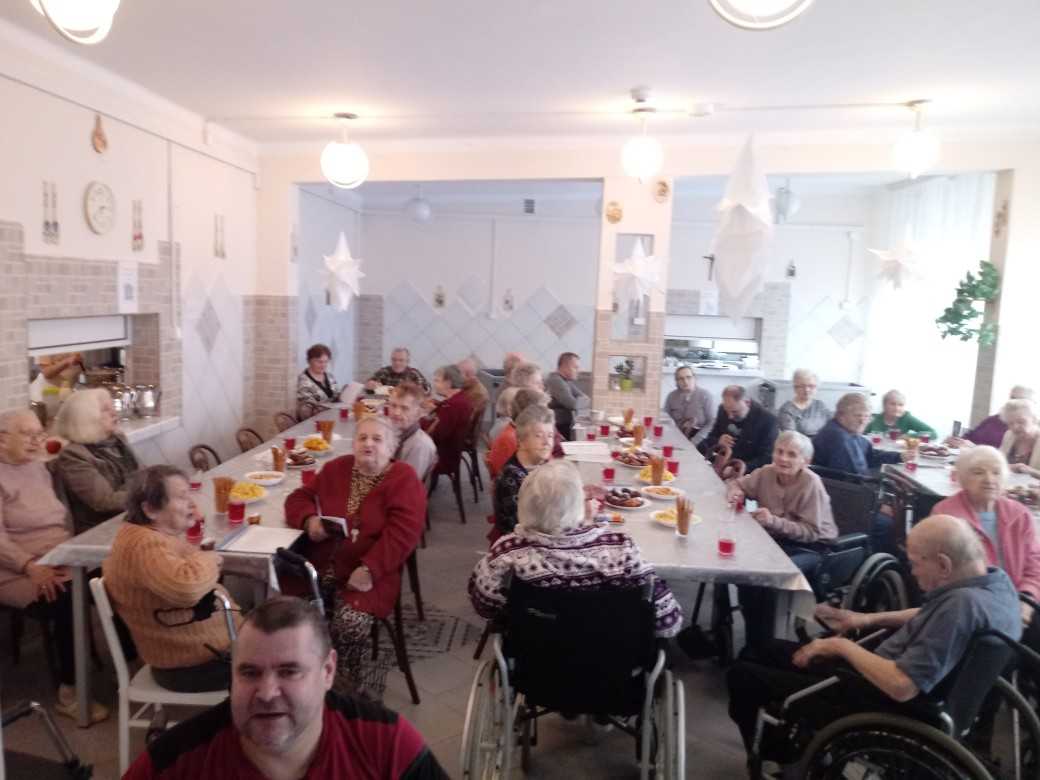 mieszkańcy DPS siedzą przy stołach