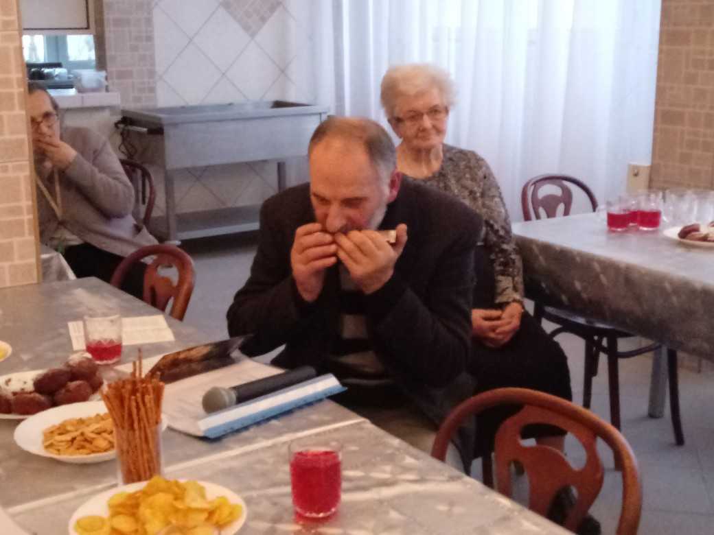 mieszkaniec DPS gra na harmonijce ustnej