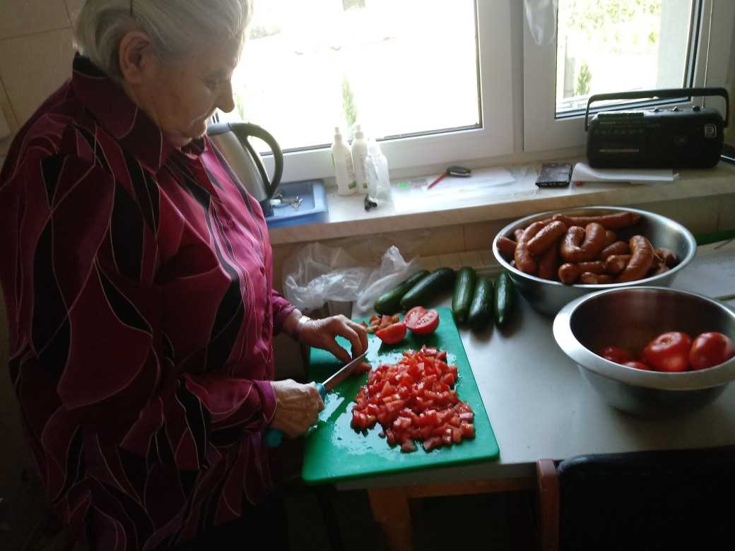 mieszkanka przygotowuje sałatkę grecką