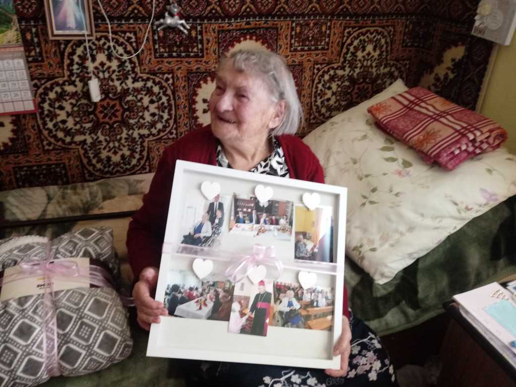 najstarsza mieszkanka DPS prezentuje ramkę ze zdjęciami