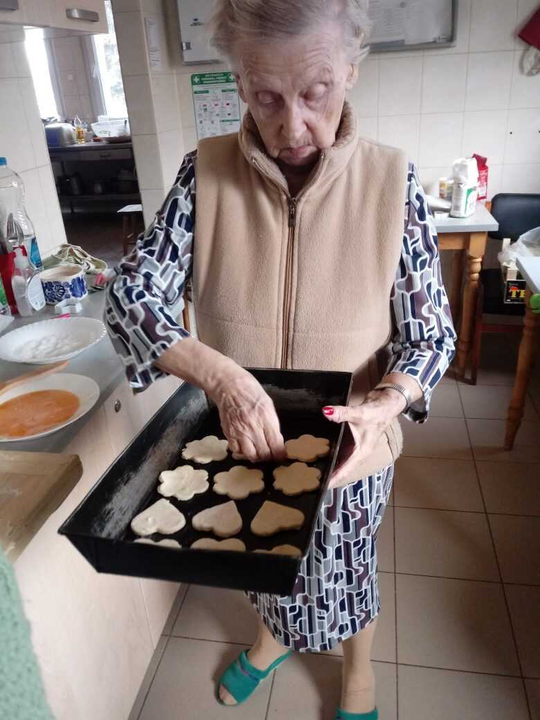 mieszkanka DPS pomaga w pieczeniu ciastek