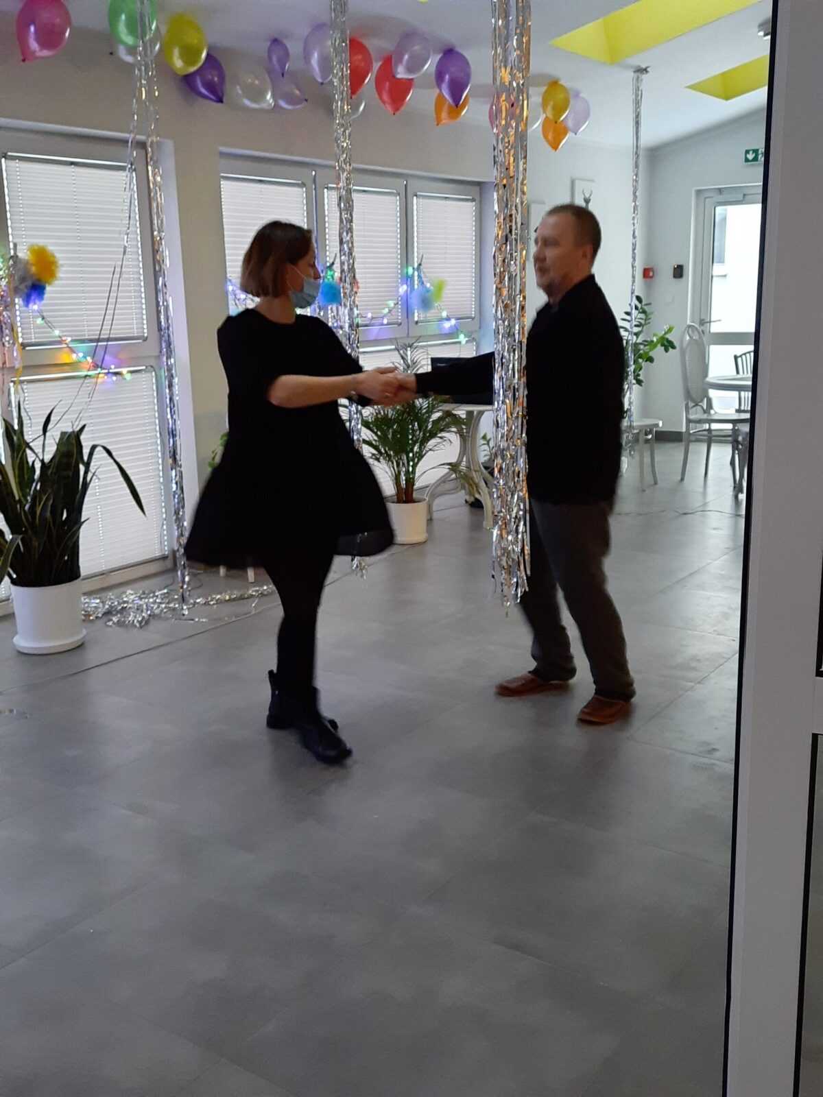 pracownica i mieszkaniec DPS tańczą