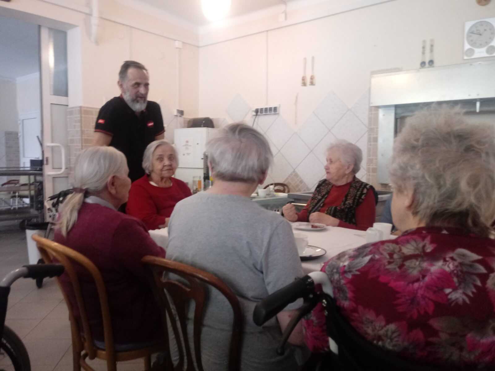 pracownik DPS składa życzenia mieszkankom i pracownicom z okazji dnia kobiet