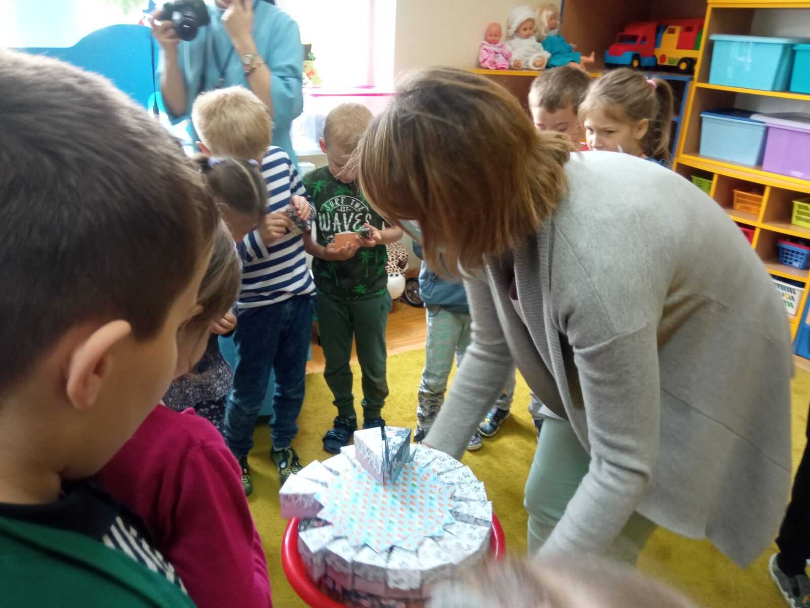 Dzieci z przedszkola sądiadującego z DPS częstują się słodkościami, które otrzymały od mieszkańców DPS z okazji dnia dziecka.