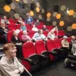 w sali kinowej na fotelach siedzą starsi ludzie